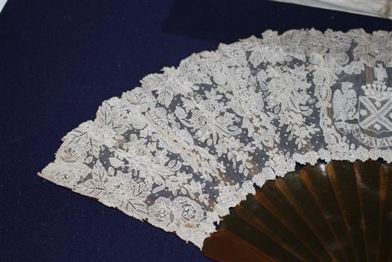 A Maison Patte-Hannot boxed lacework fan, with simulated amber sticks, inset with a rose diamond set crowned monogram, the lacework wit